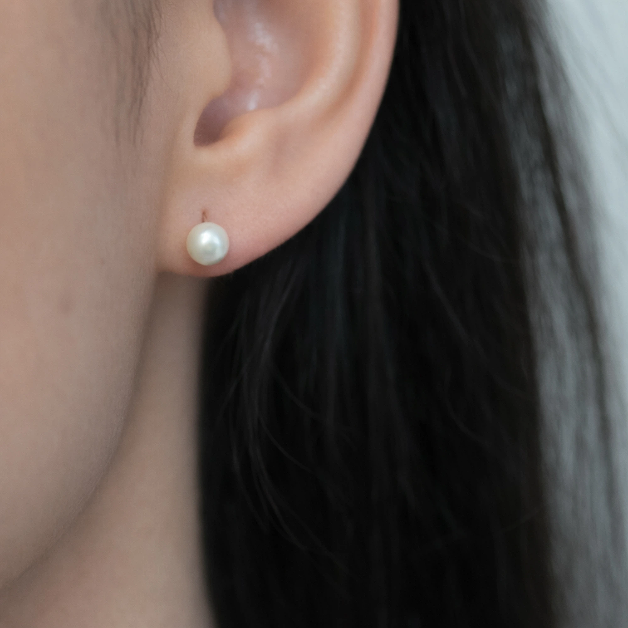 Cercei argint perla alba pearl glow cadru apropiat ureche Cercei argint perla alba pearl glow cadru apropiat ureche